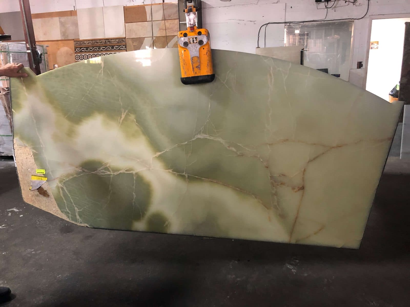 Green onyx slab on a vacuum lifter in the shop