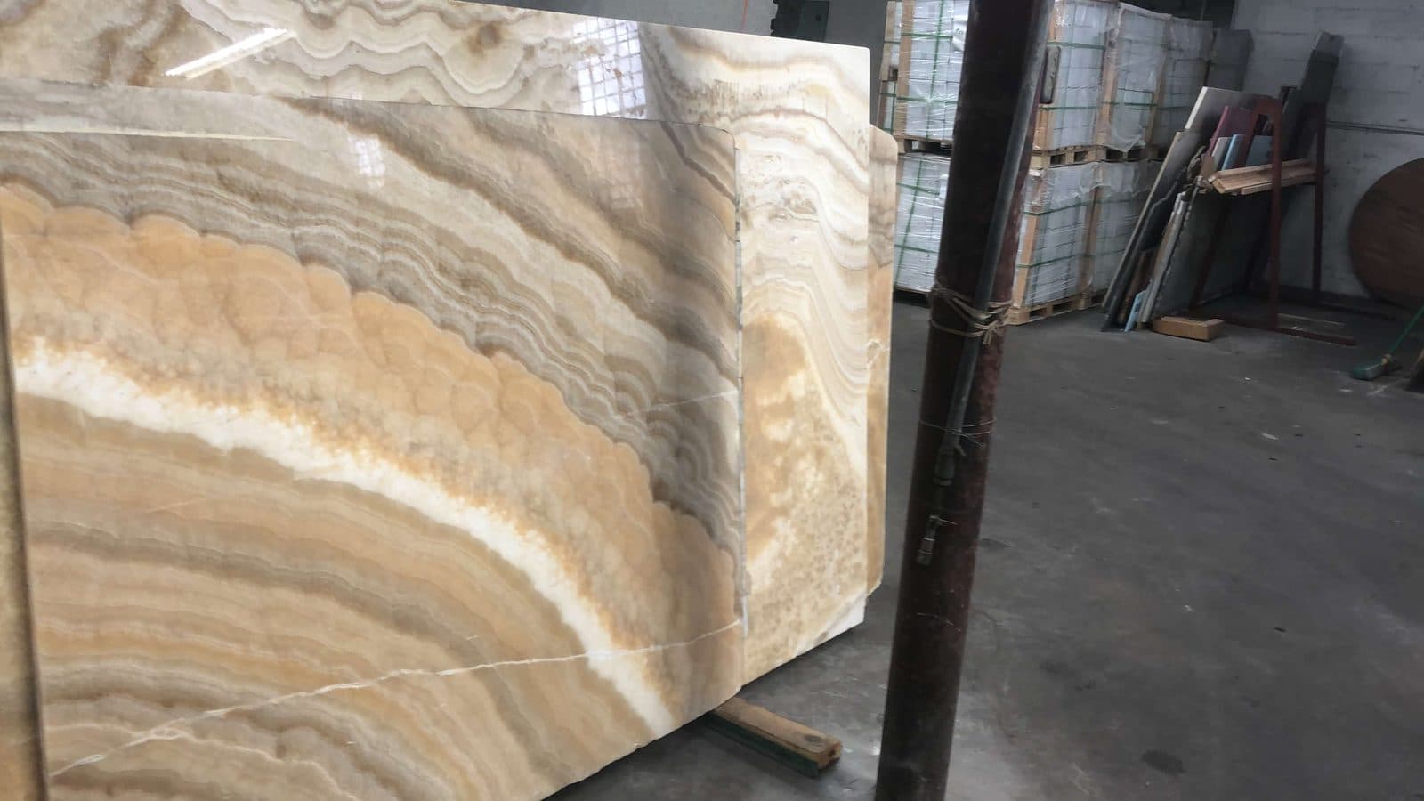Onyx slabs standing in a real warehouse