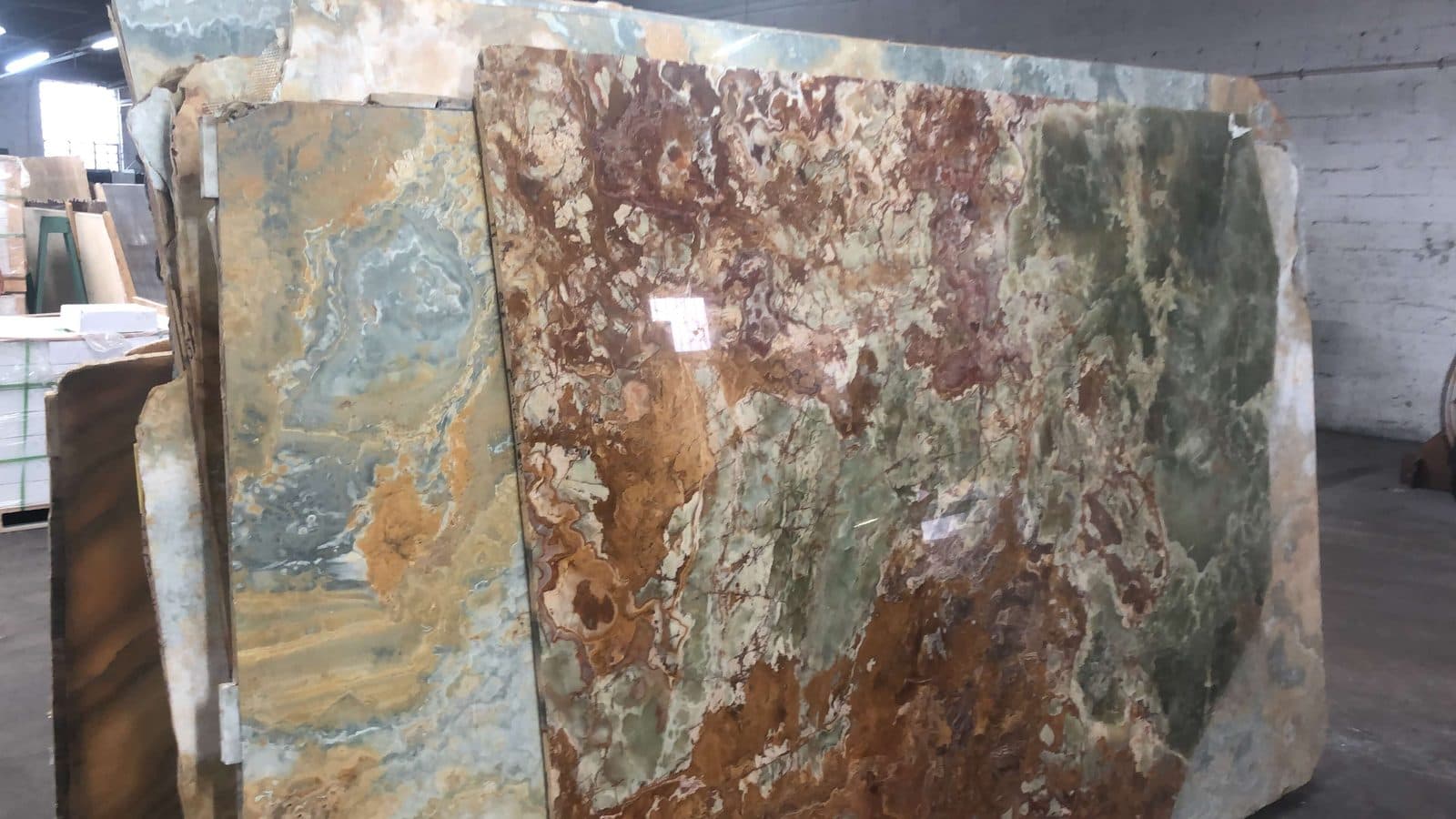 Green and rust onyx slabs in the warehouse
